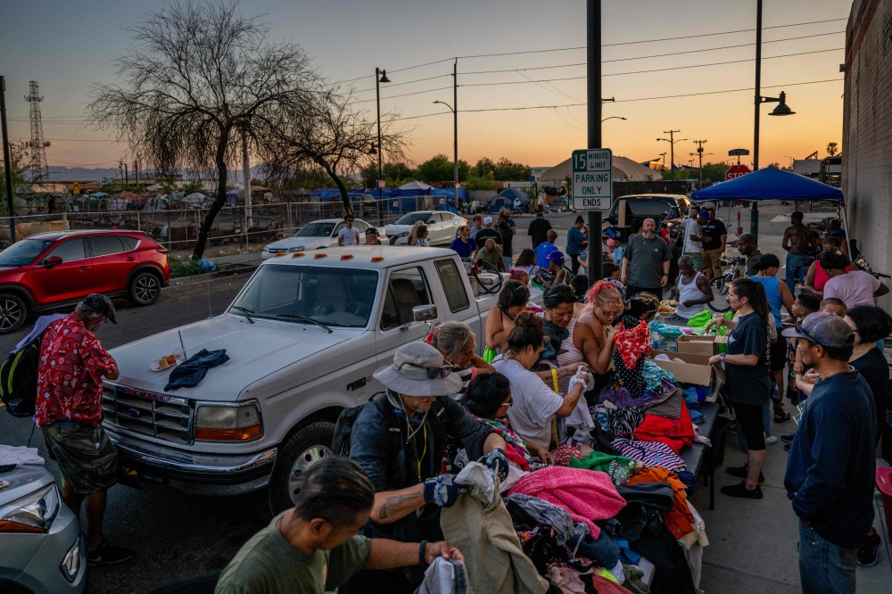 Members of the Judah Arise Ministries feed and provide clothing for homeless residents in a section of the ‘The Zone’ encampment on July 14, 2023 in Phoenix, Arizona. — AFP pic