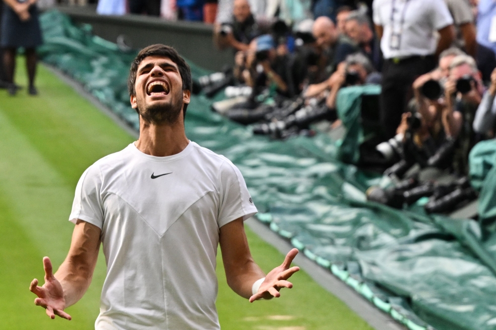 Carlos Alcaraz dari Sepanyol meraikan kejayaan menewaskan pemain Serbia Novak Djokovic semasa perlawanan tenis akhir perseorangan lelaki pada hari terakhir Kejohanan Wimbledon 2023 di Kelab Tenis All England di Wimbledon 16 Julai 2023. — Gambar AFP