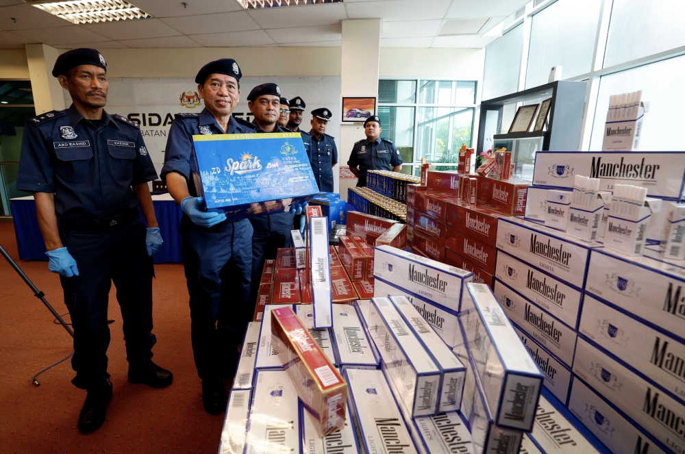 JKDM Central Zone Enforcement Operations director Wong Pun Sian with the seized cigarettes and alcohol in Port Klang, July 20, 2023. — Bernama pic 