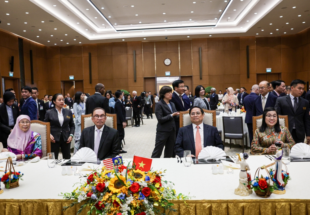 Prime Minister Datuk Seri Anwar Ibrahim, his wife Datuk Seri Dr Wan Azizah Wan Ismail, Prime Minister of Vietnam Pham Minh Chinh with his wife Le Thi Bich Tran at an official dinner hosted by Pham at The Presidential Palace in Hanoi, July 20, 2023. — Bernama pic 