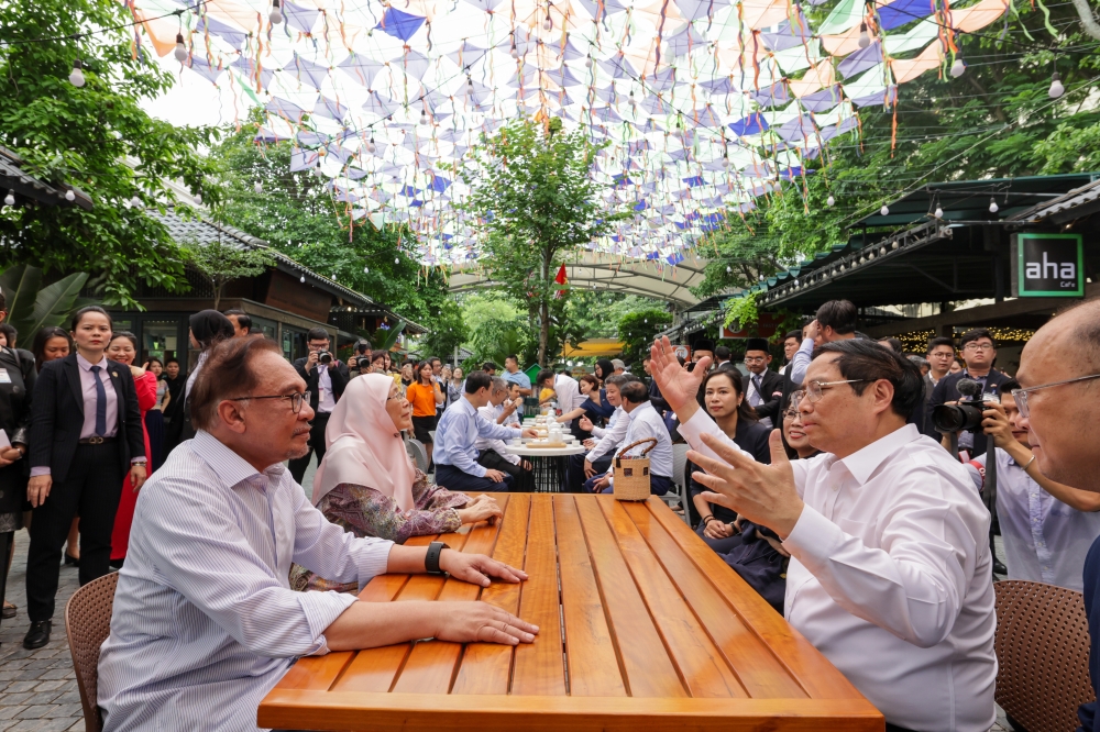 Prime Minister Datuk Seri Anwar Ibrahim and his wife Datuk Seri Dr Wan Azizah Wan Ismail along with Vietnamese counterpart Pham Minh Chinh and his wife Le Thi Bich Tran are seen during their visit to Hanoi Book Street July 21, 2023. — Bernama pic