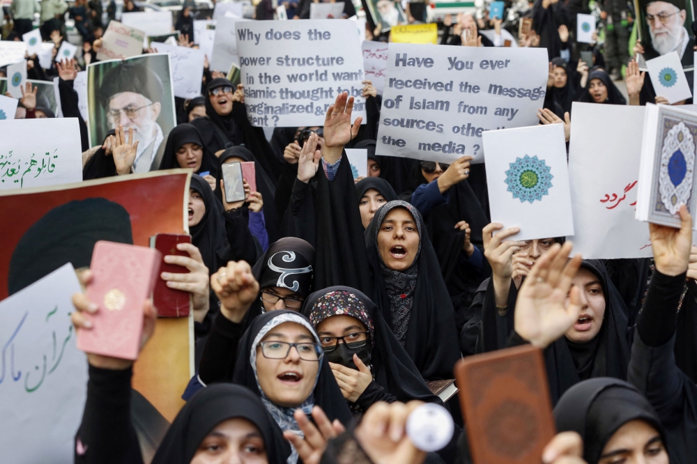 Iranian students lift placards and chant slogans during a demonstration denouncing the burning of the Koran in Sweden, Islam’s holy book, in front of Swedish embassy in Tehran on July 21, 2023. ― AFP pic