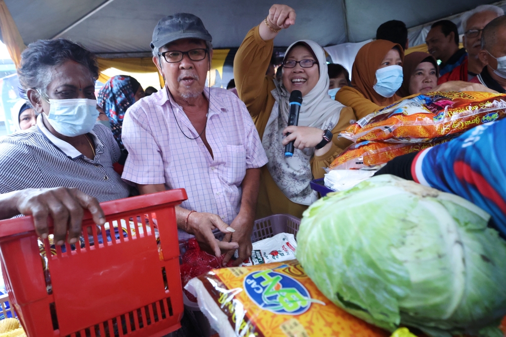 Fuziah Salleh helps to promote an item at the Rahmah sale organised by the Ministry of Domestic Trade at Taman Ria Jaya in Kedah, July 19 2023. ― Bernama pic