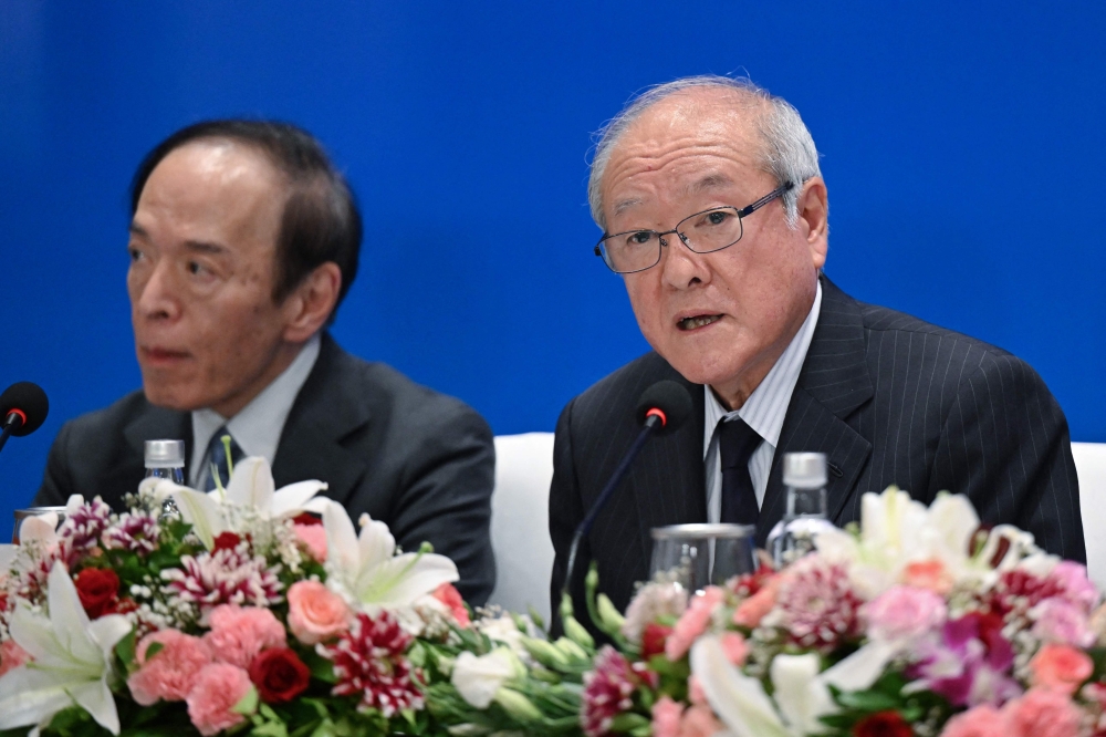 File photo of Japan Finance Minister Shunichi Suzuki (right) addressing the media as Bank of Japan governor Kazuo Ueda looks on, after the G20 Finance Ministers, Central Bank Governors (FMCBG) and Finance & Central Bank Deputies (FCBD) meetings, in Ahmedabad on July 18, 2023. ― AFP pic