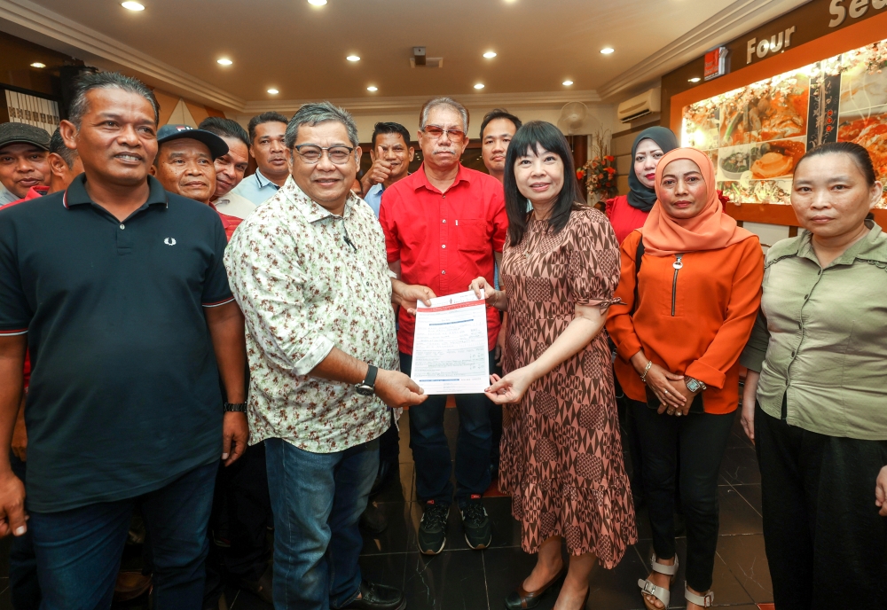 Former Kelantan Bersatu deputy chairman Mohd Zulkifli Zakaria handing over his application form to join DAP to party secretary Lim Hui Ying in Kota Baru July 23, 2023. — Bernama pic