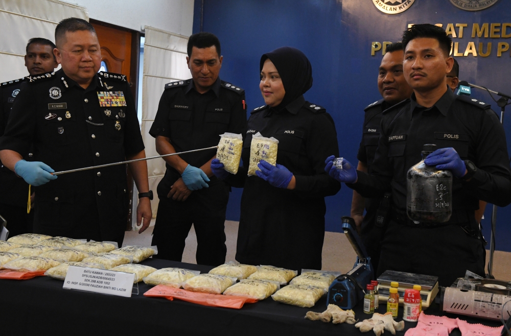 Penang police chief Datuk Khaw Kok Chin (left) shows the drugs worth RM135,250 seized in raids during a press conference at the Penang Police Contingent Headquarters in George Town July 23, 2023. — Bernama pic