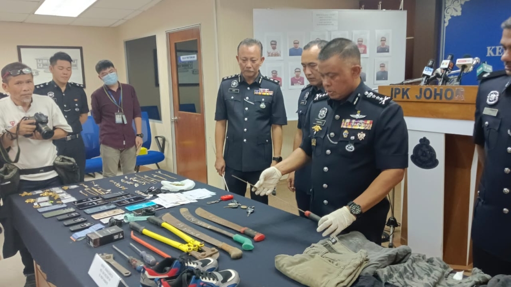 Johor police chief Datuk Kamarul Zaman Mamat showing the weapons and burglary tools seized from the suspects of the Geng Topeng on July 24, 2023, who were earlier arrested in two special operations on July 13. — Picture by Ben Tan