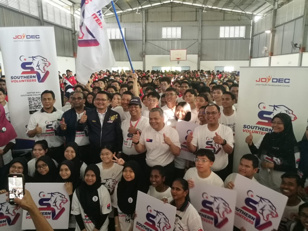 Johor Youth, Sports, Entrepreneurial Development, Cooperatives and Human Resources Committee chairman Mohd Hairi Mad Shah (in black jacket) with the volunteers after launching the state-level schools Southern Volunteers Youth Squad at Sekolah Menengah Kebangsaan Dato' Jaafar in Johor Baru July 25, 2023. — Picture by Ben Tan