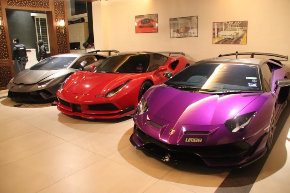 The raiding teams also confiscated 17 luxury vehicles including a Ferrari and a Maserati. — Picture from Twitter/Bernama 