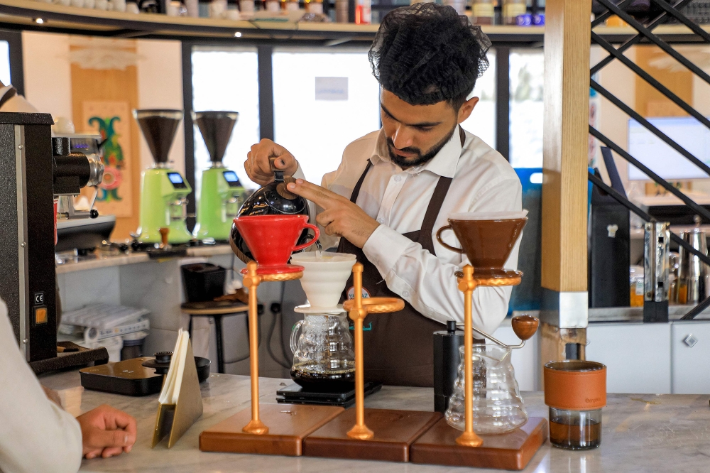 A speciality coffee shop employee serves filtered coffee at the shop in Yemen's Huthi-held capital Sanaa on July 18, 2023. — AFP pic