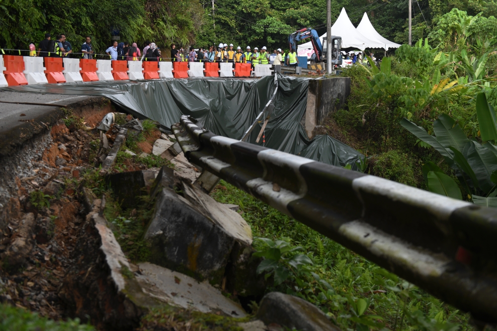 Works Minister Datuk Seri Alexander Nanta Linggi inspects the FT006 Jalan Balik Pulau-Teluk Bahang road which was cut off due to a landslide in Balik Pulau, July 27, 2023. The repair work is expected to be completed in December this year. — Bernama pic