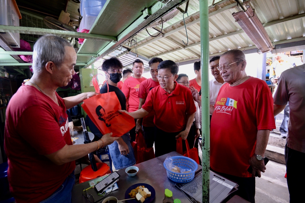 Padang Kota candidate Chow Kon Yeow greets a voter during his walkabout in George Town July 29, 2023. Also present is Tan Sri Lim Kit Siang (right). — Picture by KE Ooi