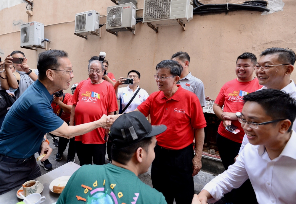 Padang Kota candidate Chow Kon Yeow greets a voter during his walkabout in George Town July 29, 2023. Also present is Tan Sri Lim Kit Siang. — Picture by KE Ooi