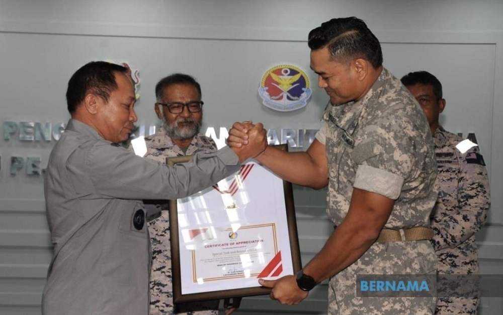 MMEA Maritime Enforcement and Coordination Division director Rear Admiral Aminuddin Abdul Rashid receives of a certificate of special appreciation from the Indonesian Maritime Security Agency head and Indonesian National Armed Forces Vice Admiral Aan Kurnia. — Picture via Twitter/Bernama