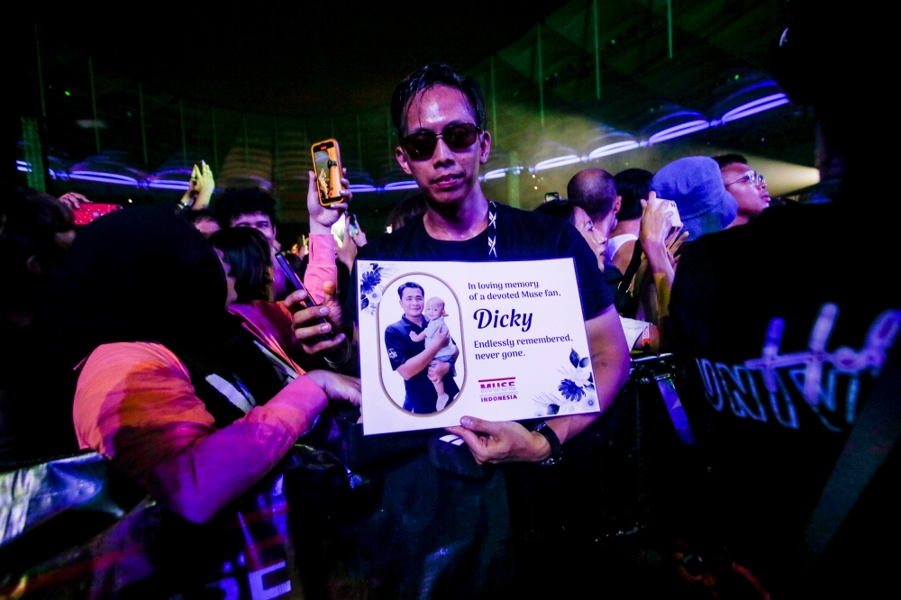 Indonesian fan holding a banner in memory of a late fellow Muse fan at Bukit Jalil National Stadium. — Picture by Hari Anggara