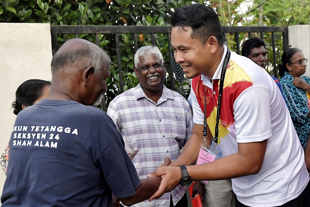 Pakatan Harapan’s candidate for Batu Tiga state seat Danial Al-Rashid Haron (right) greets a voter during his walkabout in Shah Alam July 30, 2023. — Bernama pic