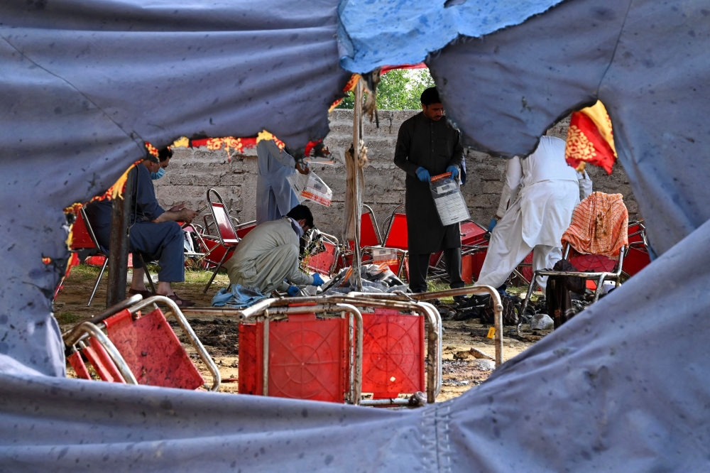 Police at the site of the bombing that killed at least 54 people, including 23 children. — AFP pic