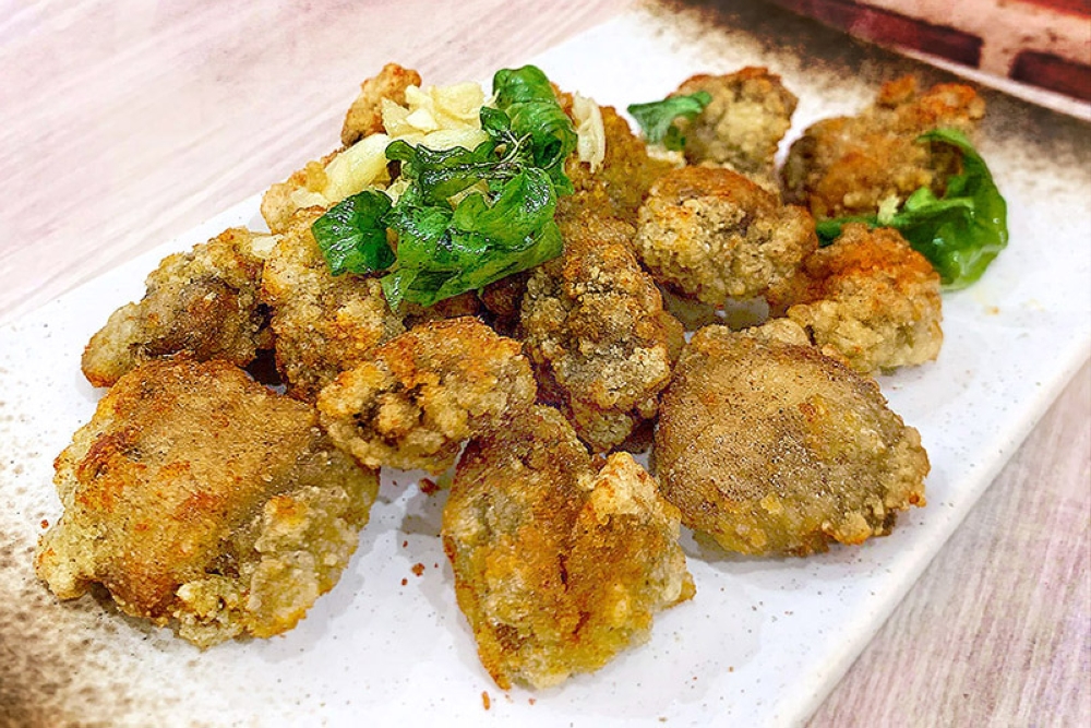 Salted crispy fried chicken, topped with raw garlic and lightly fried basil leaves.