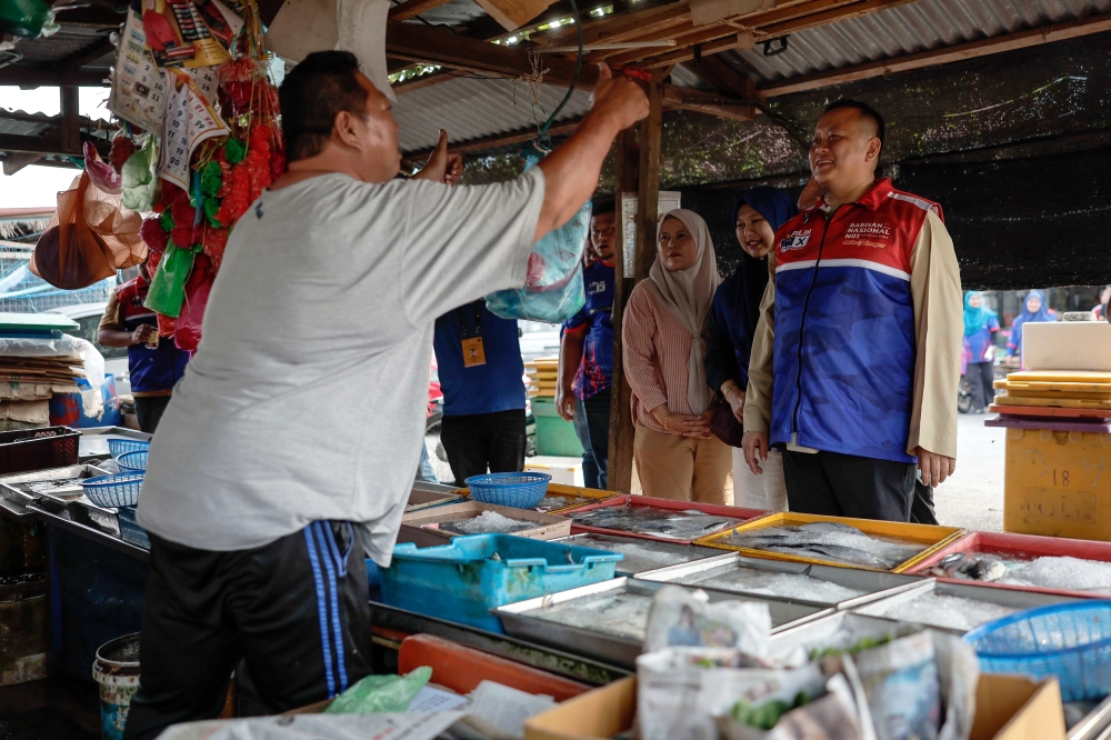 Barisan Nasional candidate for Sungai Air Tawar Datuk Rizam Ismail meets voters during a walkabout at Pekan Parit Baru in Sungai Air Tawar July 29, 2023. — Bernama pic