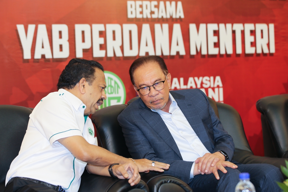 Prime Minister Datuk Seri Anwar Ibrahim talks to MIC president Tan Sri SA Vigneswaran during the MIC members and leaders meeting at MIC headquarters in Kuala Lumpur, August 2, 2023. — Picture by Ahmad Zamzahuri