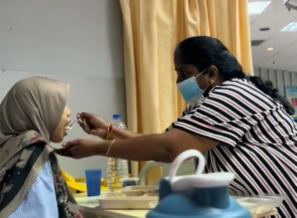 Indian woman praised by social media users for feeding a visually-impaired patient in Kedah hospital. — Screengrab via TikTok/divyasree0605