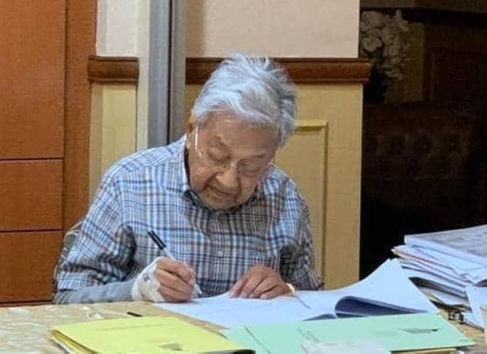 Tun Dr Mahathir Mohamad is pictured writing in his room at the National Heart Institute in Kuala Lumpur on August 3, 2023. — Picture courtesy of Tun Dr Mahathir Mohamad’s office