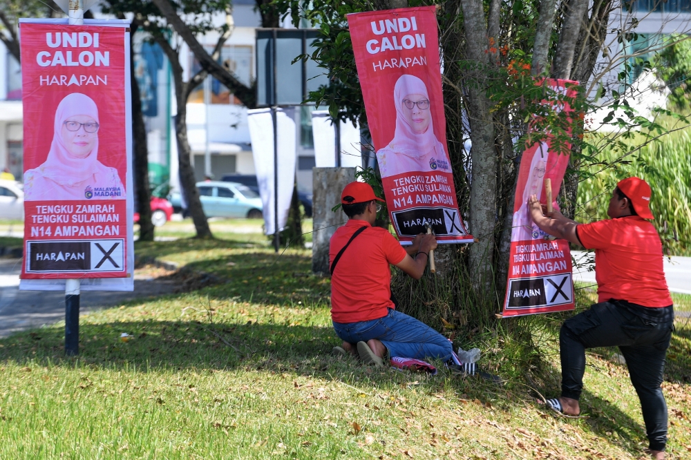 Workers hang up posters of PH-PKR candidate Tengku Zamrah Tengku Sulaiman for Dewan Undangan Negeri (DUN) N.14 Ampangan in Penghulu Cantik, Seremban, August 3, 2023. — Bernama pic 