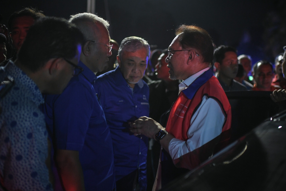 Prime Minister Datuk Seri Anwar Ibrahim (right) said Datuk Seri Ahmad Zahid Hamidi (centre) should be commended for resisting an alleged request by Tun Dr Mahathir Mohamad to close down Umno. — Bernama pic