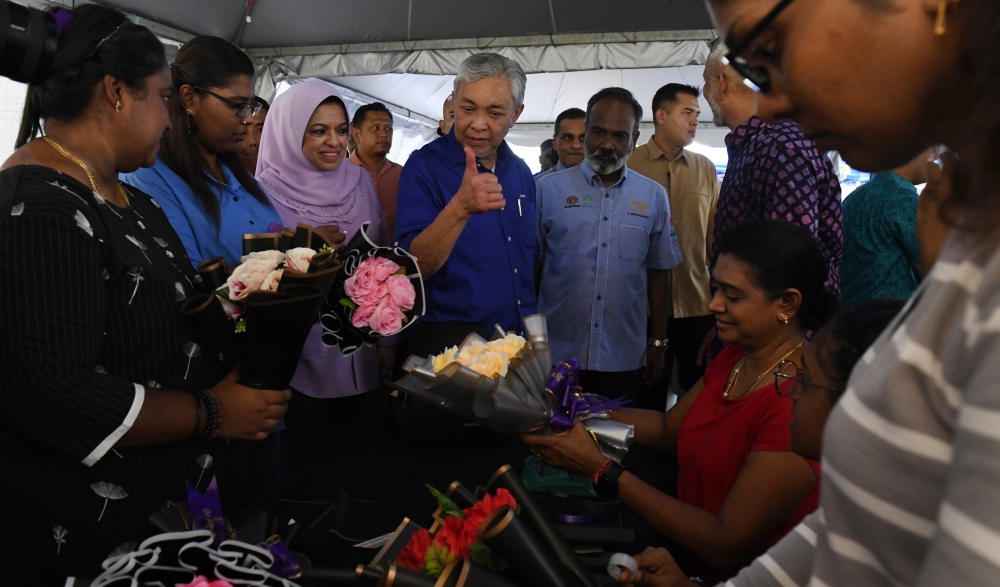 Deputy Prime Minister Datuk Seri Dr Ahmad Zahid Hamidi and Umno’s Women and Family Affairs Council chairman Tan Sri Shahrizat Abdul Jalil speak to florists during the MYFuturejobs Career Carnival with Hawa at Kepala Batas August 5, 2023. — Bernama pic