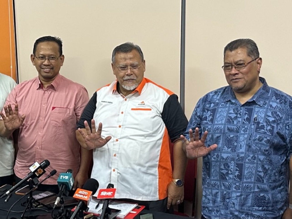 Johor Amanah chief Aminolhuda Hassan (centre) and Suhaizan Kaiat (left) during the press conference at the Johor Amanah state office in Bandar Baru Kangkar Pulai, Skudai August 7, 2023. — Picture by Ben Tan