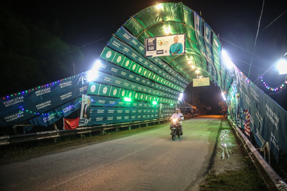 Perikatan Nasional (PN) and PAS flags in the shape of a tunnel on the main road in conjunction with the Kedah 15th State Election campaign at Kampung Hujung Bandar in Sik, Kedah, August 7, 2023. — Picture by Yusof Mat Isa