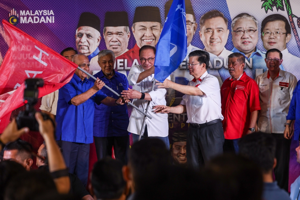 Prime Minister Datuk Seri Anwar Ibrahim presents the party flag to Penang Pakatan Harapan chairman Chow Kon Yeow (third from right) during the ‘Madani Unity’ roadshow and the launch of the Penang Unity Machinery at the Seberang Jaya Expo site in Permatang Pauh July 17, 2023. — Bernama pic
