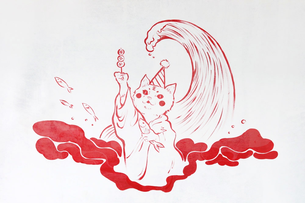 The walls are adorned with striking red murals of cats.