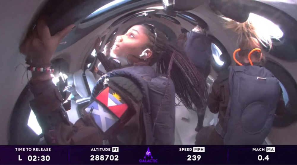 Anastatia Mayers (front left), 18, Jon Goodwin (back right), 80, and Chief Astronaut Instructor Beth Moses (front R) looking out of windows while in Space. — Virgin Galactic / AFP pic