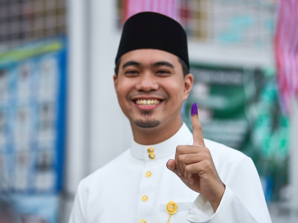 Clad in white Baju Melayu with samping, Abdul Qayyim Roslan, who works at a company in Bangsar, arrived at the polling centre at Sekolah Menengah Kebangsaan (SMK) Seri Keramat at 7.57am to cast his vote. — Bernama pic 