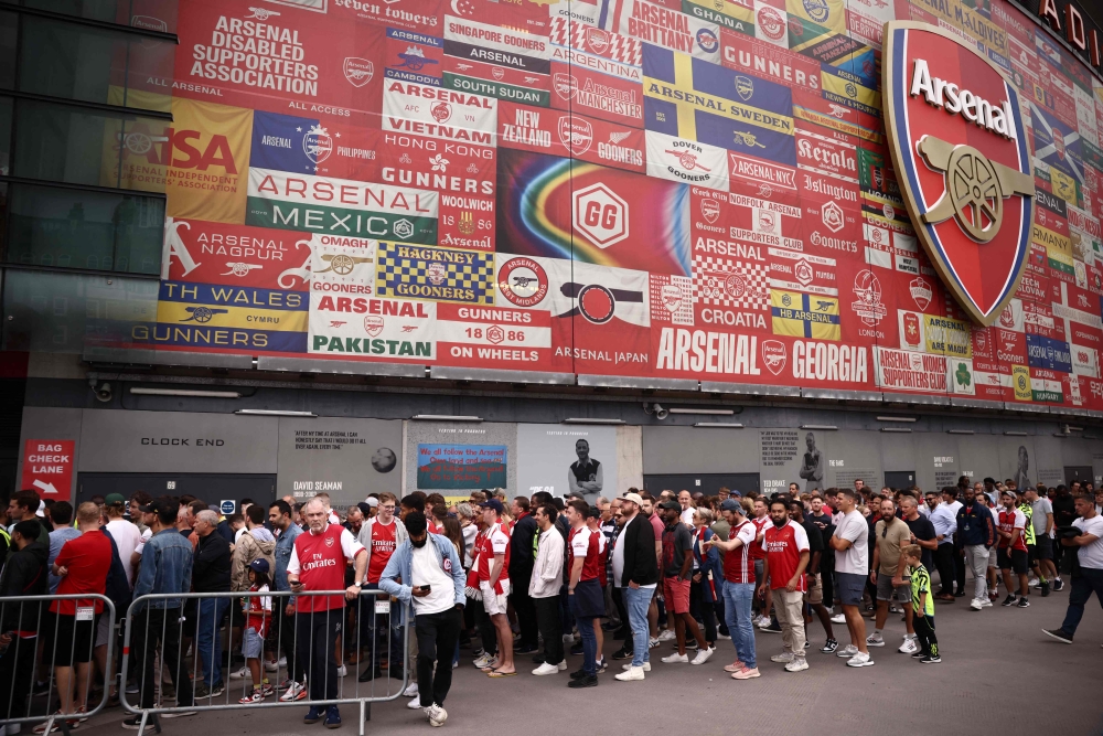Fans queue to pass the ticket barriers to enter the Emirates Stadium, after the scheduled kick-off time, in London on August 12, 2023, for the English Premier League football match between Arsenal and Nottingham Forest. — AFP pic 