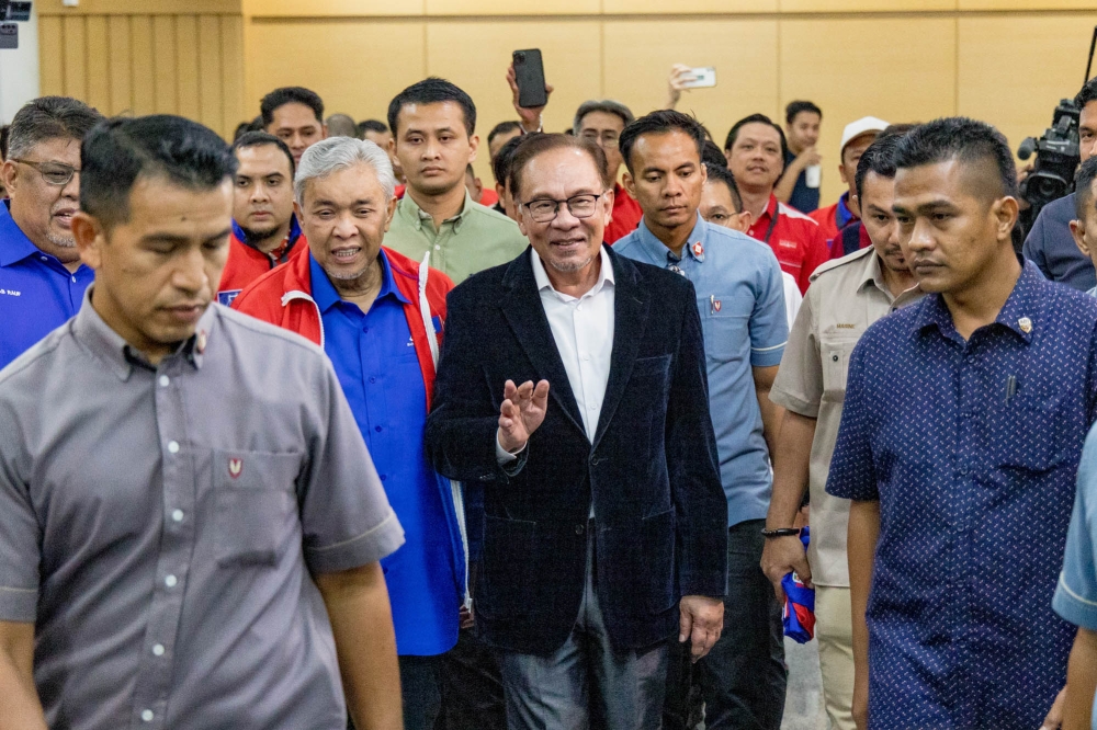 Prime Minister and Pakatan Harapan chairman Datuk Seri Anwar Ibrahim arrives at World Trade Centre in Kuala Lumpur August 12, 2023. With him is Deputy Prime Minister and Umno president Datuk Seri Ahmad Zahid Hamidi. — Picture by Firdaus Latif