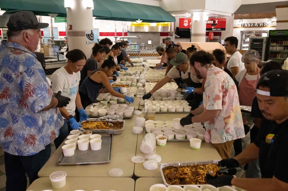 Volunteers prepare free meals to donate to West Maui families affected by wildfires, at the University of Hawaii Maui College in Kahului, central Maui, Hawaii August 13, 2023. — AFP pic