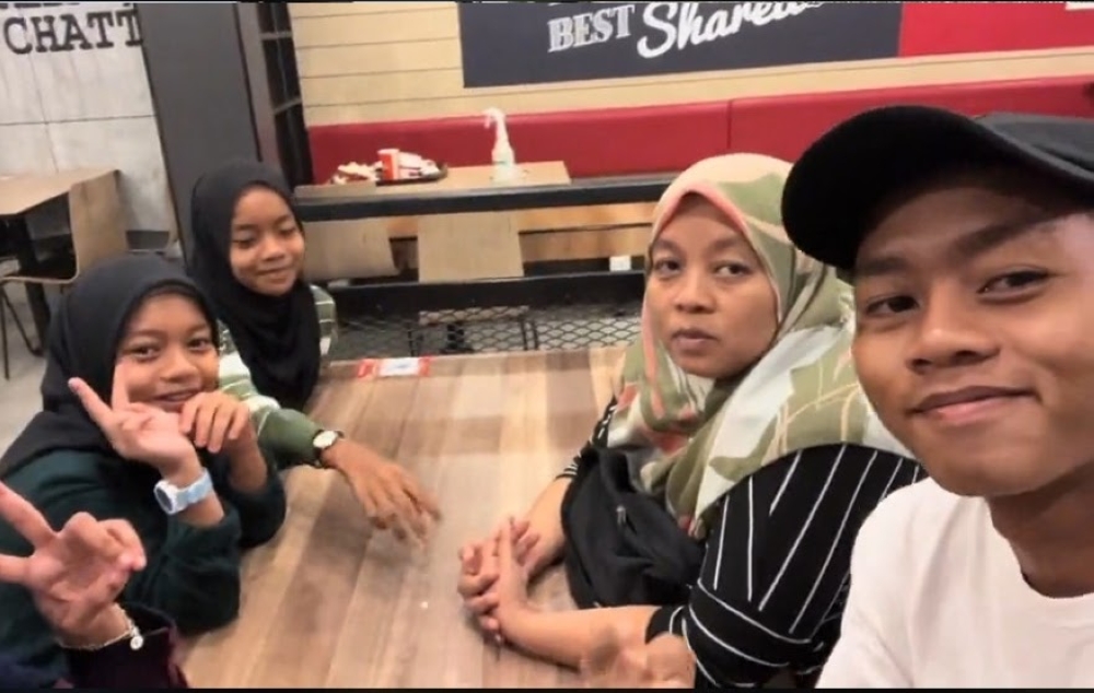 Wan, his mum and three younger sisters aged 13, 12 and nine, respectively, enjoying their KFC treat — Screengrab via TikTok/_garbageman WAN