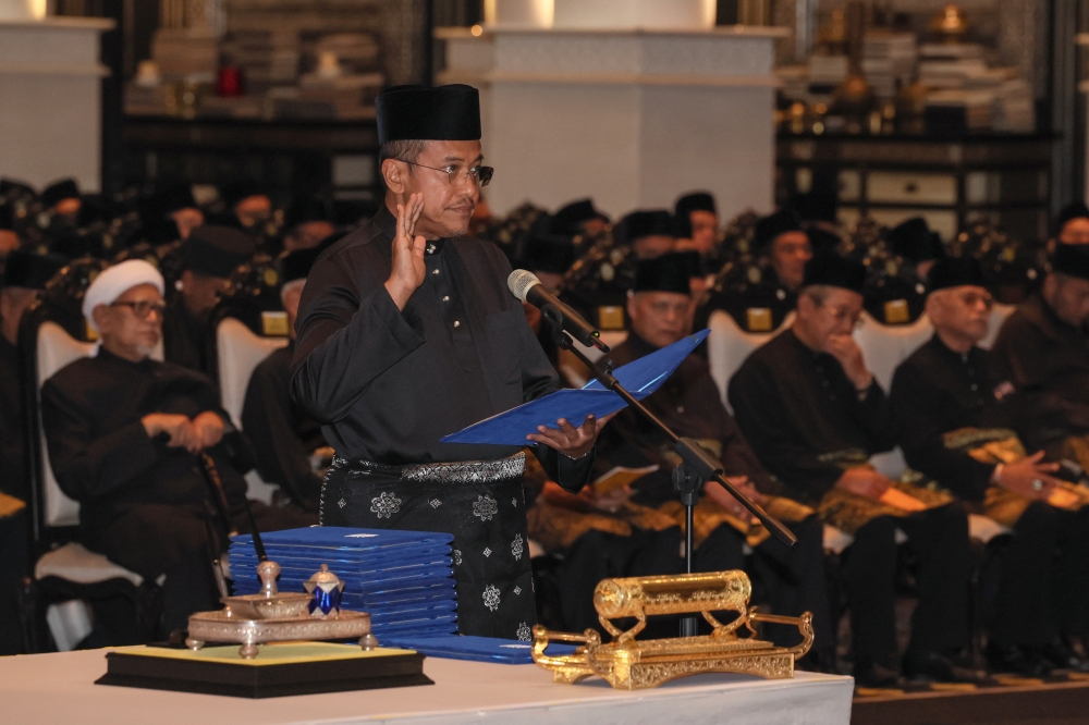 PAS vice-president Datuk Seri Ahmad Samsuri Mokhtar takes his oath of office at 3.18pm before the Sultan of Terengganu Sultan Mizan Zainal Abidin at Istana Syarqiyyah in Chendering, August 15, 2023. — Bernama pic 