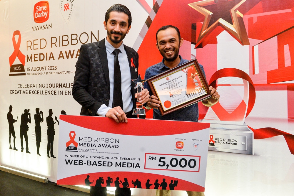 Malay Mail journalist Milad Hassandarvish and photographer, Ahmad Zamzahuri with their win at the Red Ribbon Media Award 2023. —Picture by Miera Zulyana