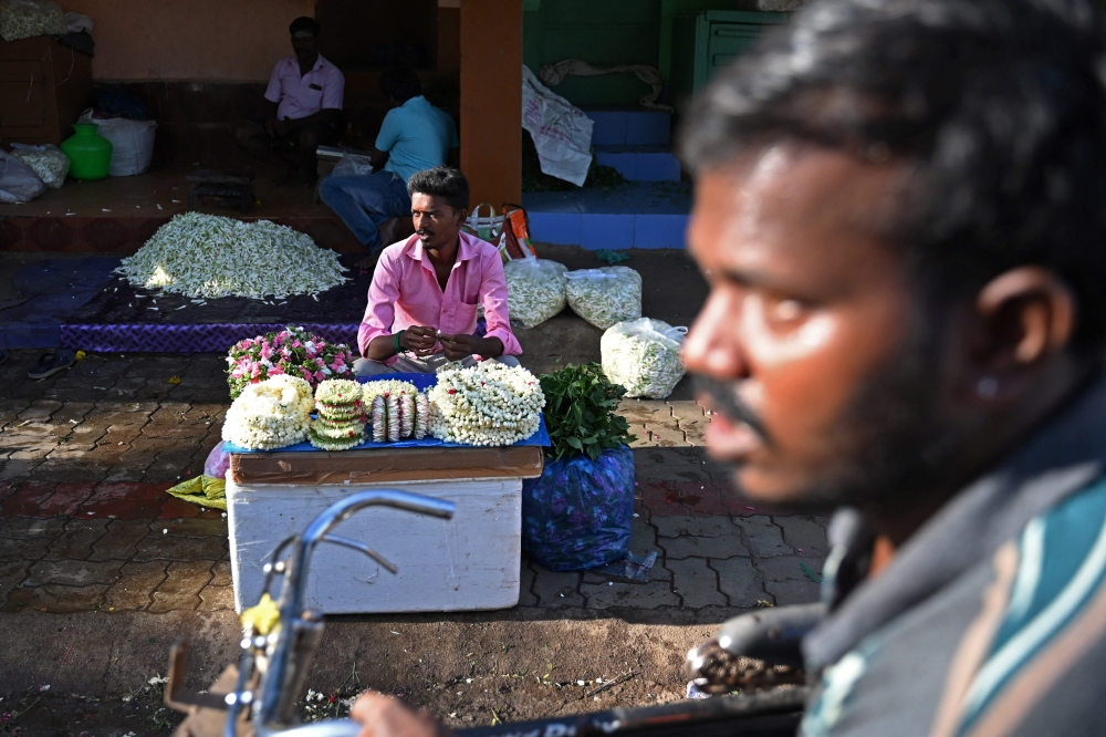 In this picture taken on June 28, 2023, a vendor selling jasmine flowers waits for customers at a wholesale flower market in Madurai. — AFP pic 