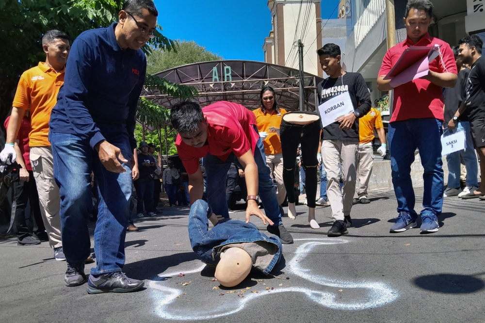 This picture taken on July 27, 2023 shows Indonesian police conducting a re-enactment of a robbery and murder amid a spate of violent crimes by ‘begal’. — AFP pic