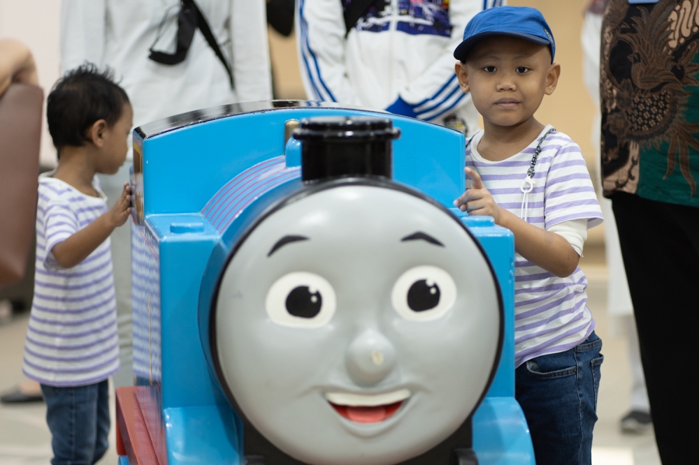 Young leukaemia patient, Ahmad (right), experienced the ultimate 'Thomas and Friends' birthday train ride this morning. — Picture by Raymond Manuel