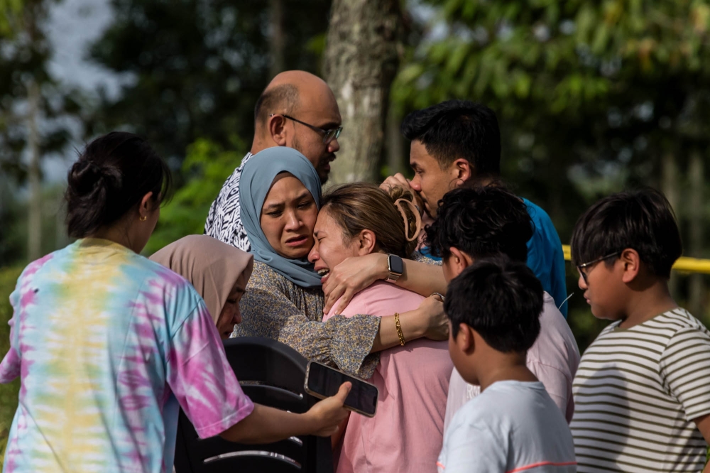 Family members pictured at the site of the plane crash in Elmina, Shah Alam, August 17, 2023. — Picture by Firdaus Latif