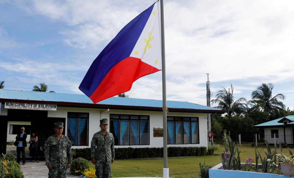 File photo of Filipino soldiers standing at attention near a Philippine flag at Thitu island in disputed South China Sea April 21, 2017. — Reuters pic