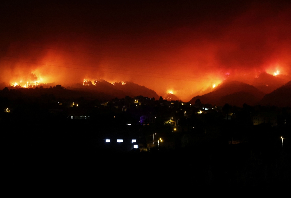 A view shows fire over the mountains in the village of La Victoria, as wildfires rage out of control on the island of Tenerife, Canary Islands, Spain August 19, 2023. — Reuters pic