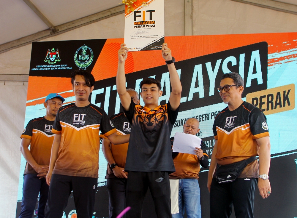 Deputy Youth and Sports Minister Adam Adli Abd Halim presenting the official plaque to Muaythai athlete Mohamad Rifdean Masdor at the Perak-level Fit Malaysia Programme at the Youth and Sports Complex in Ipoh August 20, 2023. — Bernama pic