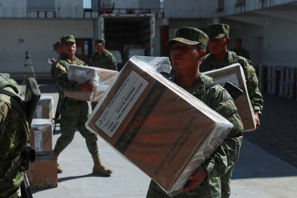 Soldiers carry ballot boxes and voting materials to a polling station ahead of the presidential election. — Reuters pic