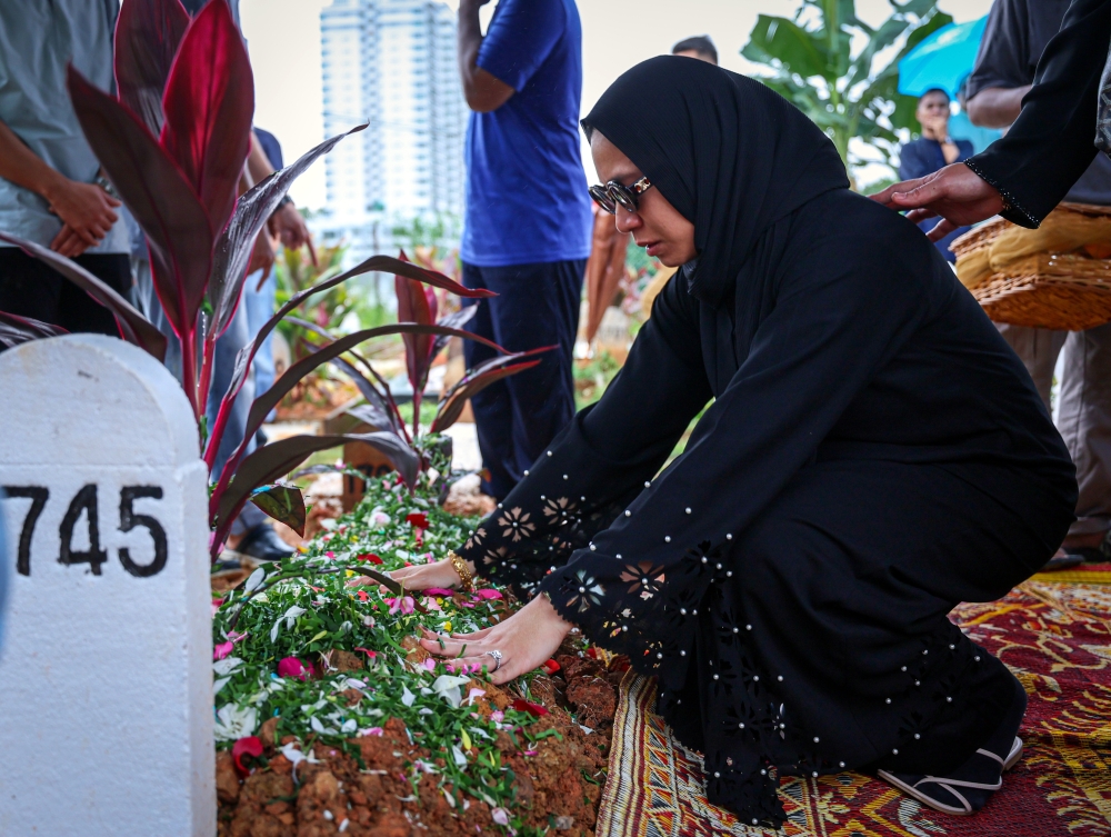 Late pilot Shahrul Kamal Roslan;s wife is seen at his funeral at the Kampung Klang Gate Muslim cemetery in Hulu Klang August 20, 2023. — Bernama pic